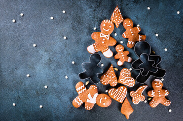 christmas tree made from gingerbread cookies on dark blue background with copy space for text. Gingerbread cookie with kitchen utensils. new year and christmas postcard. Assorted cookies.