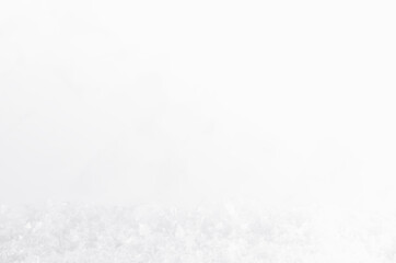 White sparkling fluffy fake snow with snowflakes as decorative abstract winter soft light background, blur, closeup. Christmas and new year background for design card, brochure, flyer, poster.