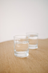 Glass of water on wooden table at modern style cafe. Tasty morning drinks.