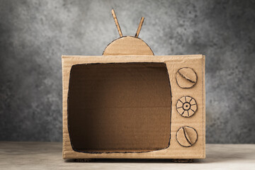 Blank cardboard TV on an abstract background, template for the designer
