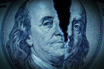 Close up torn one hundred US Dollar bill as symbol of global economic crisis.