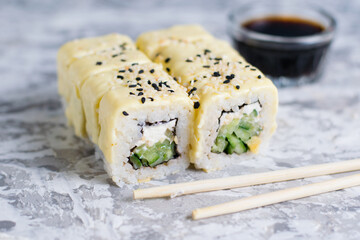 Sushi rolls with cheese and cucumber on a light background with copy space
