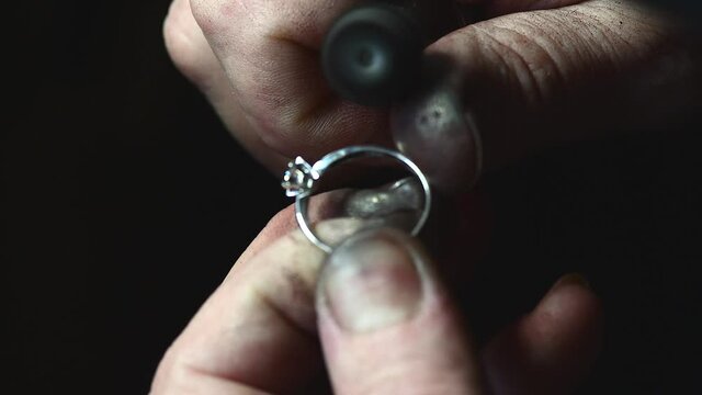 Closeup of wedding ring polishing by caicasian jeweler isolated, 4k footage