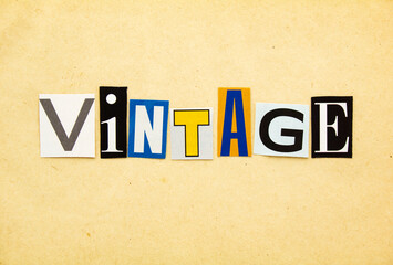 VINTAGE - word from cutting magazine clippings on old beige sheet of paper background. Retro and vintage concept.