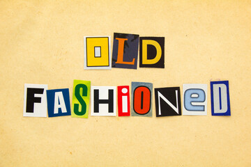 OLD FASHIONED - word from cutting magazine clippings on old beige sheet of paper background. Retro and vintage concept.