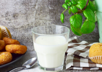 Close up, glass of milk, next to it muffins and doughnuts on a plate, decorative contour.
