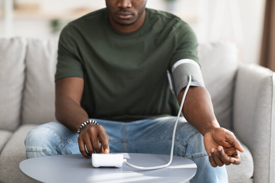 Unrecognizable Black Man Checking Blood Pressure At Home