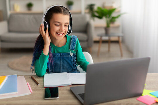 Girl using personal computer, wearing wireless headset