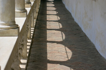 Fototapeta na wymiar Sunny building corridor colonnade shadow pattern