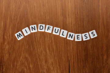 Mindfulness text word message on wooden background.  Concept of being conscious of something. 