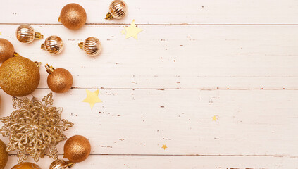 Fototapeta na wymiar Christmas or New Year Decoration, background. Ornament with gold Christmas baubles, snowflakes and stars on an old white wooden table. Banner.