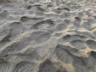 Footprints in the sand at sunset, background texture