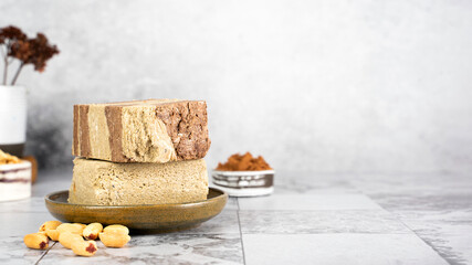Tasty eastern sweet dessert halva from sunflower seeds, cocoa and tahini on gray background.Traditional dessert confection in Middle East, Balkans and west Asia.Horizontal.Copy space