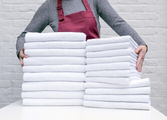 a lot towel white cleaning laundry hotel housemaid stack clean hand woman