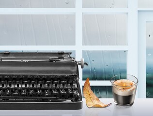 Old typewriter on a table with autumn leaves