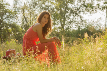 Woman sitting and looking into camera in the woods