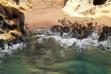 Beach and waves from top view. Turquoise water background. Summer seascape from air. Portugal Lagos Algarve. Travel concept and idea