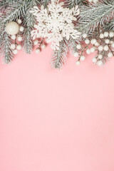 Christmas decorations at pink background. Fir tree and white christmas decorations. Flat lay image...