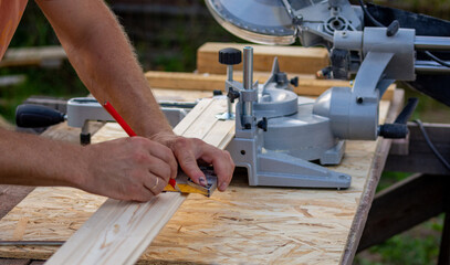 a worker marks the cut size on a wood board