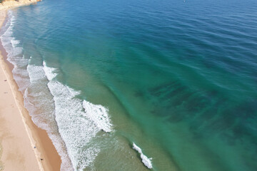 Beach and waves from top view. Turquoise water background. Summer seascape from air. Portugal Lagos Algarve. Travel concept and idea