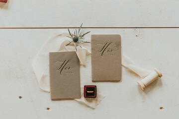his and hers vow books on white barnwood with flowers ribbon and ring 