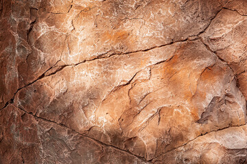 Fototapeta premium Textured brown rock background. Glare from the sun.