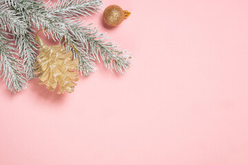 Christmas decorations at pink background. Fir tree and golden christmas decorations top view with copy space.