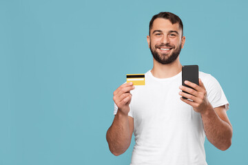 Satisfied mature caucasian male buys purchases, uses credit card and smartphone