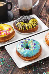 Delicious donuts decorated with different decorations on wooden table