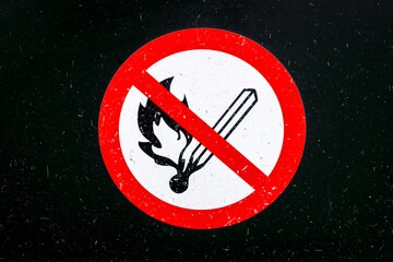 Sign on a weathered black metal plate indicating that smoking is prohibited