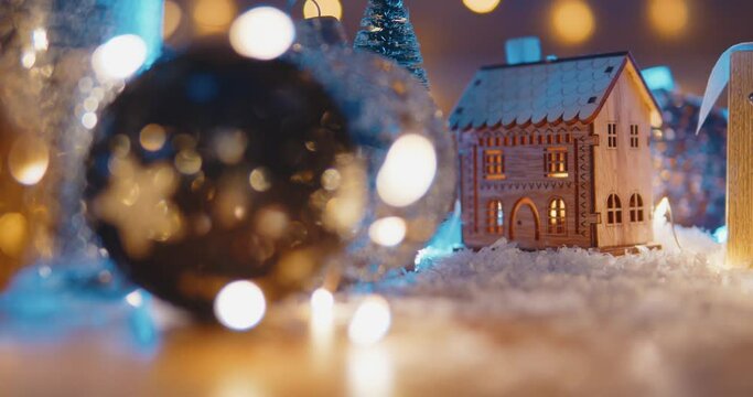 Christmas background with bright Christmas tree toys, beautiful bokeh, a toy house and candles. christmas holidays home cosiness concept