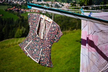 Wäscheleine mit schönem mit Blumen dekoriertem Sack mit Wäscheklammern an einer Wäschespinne.