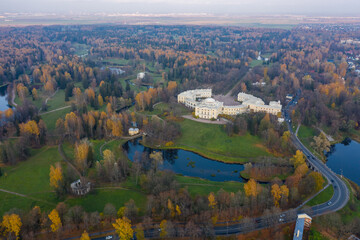 Naklejka premium Panoramic aerial view of the Pavlovsk Park and the Pavlovsk Palace on an autumn evening.Bright autumn landscape, Slavyanka river. A suburb of St. Petersburg.
