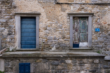 Alte Fassade mit bunt gestrichener Türe und blauer Türe in alter Fassade.
