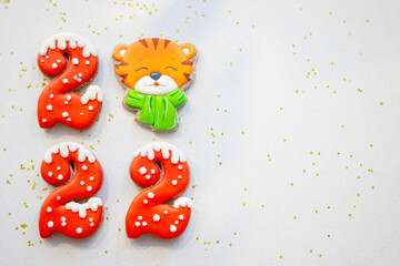 Banner for Christmas and New Year gingerbread cookies numbers 2022 on silk white background with copy space and gingerbread tiger symbol Chinese zodiac calendar
