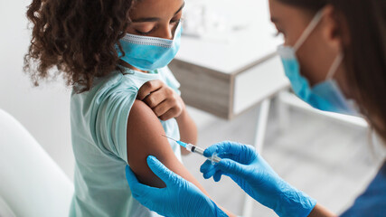 Black Girl Getting Vaccinated For Covid-19 Prevention Sitting In Clinic