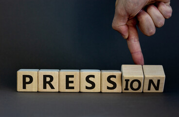 Pression to free press symbol. Businessman turns wooden cubes and changes the word pression to press. Beautiful grey table, grey background. Business and pression to free press concept. Copy space.