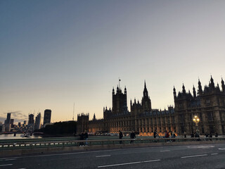 Fototapeta na wymiar London parliament big ben next to Westminster Abbey at the bridge over river thames by evening sunset warm light