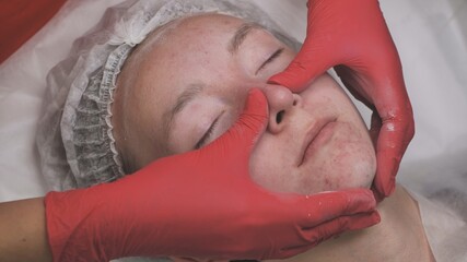 Naklejka premium Applying powder to the client's face and massage the client's problem skin.