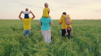 Happy family walk with children in the wheat field. Mom, dad and sons walk together in the park in summer. Concept of happy family child play. Parents, cheerful children have a rest together outdoors