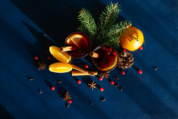 Christmas mulled wine with cinnamon stick, orange, anise and cloves on a blue background. Winter...