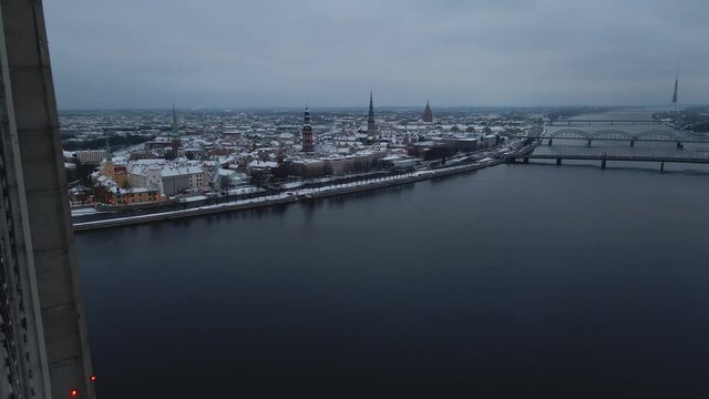 Aerial revealing shot of gloomy winter city of Riga, Latvia through Vansu bridge