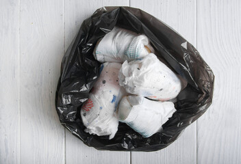 Diapers waste, dirty diapers in trash bag. Disposing of used baby nappies....