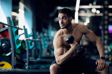 Fototapeta na wymiar Shirtless Handsome Young Muscular Arab Man Training With Dumbbells At Gym