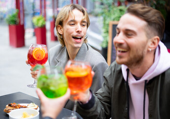 Group of young people enjoy happy hour at a bar outdoor