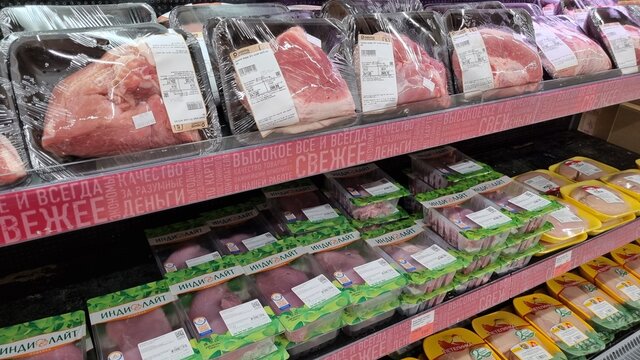 Packages with meat on a shelf in a supermarket