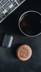 metal coffee mug next to the cookies and headphones