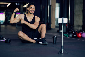 Fototapeta na wymiar Fitness Blog. Young Middle Eastern Athlete Capturing Video Content At Gym