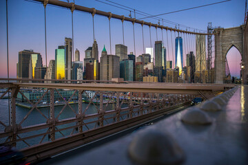 Brooklyn Bridge over East River viewed from New York City Lower Manhattan waterfront at sunrise