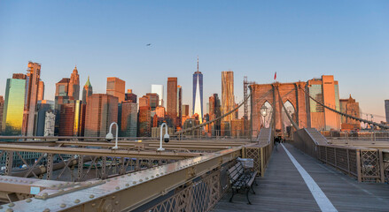 Brooklyn Bridge over East River viewed from New York City Lower Manhattan waterfront at sunrise